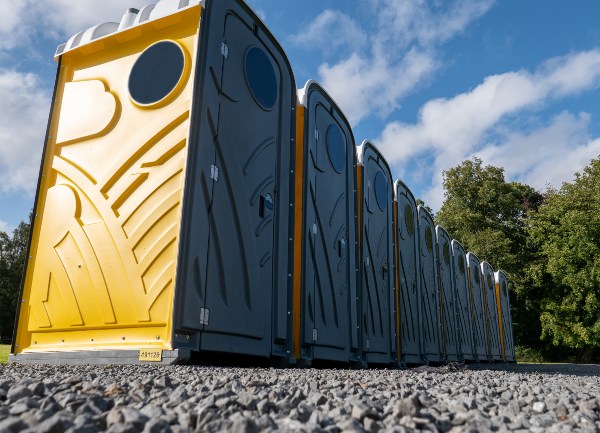 A row of portable toilets under a clear blue sky in Rancho Cordova, CA, set up for events